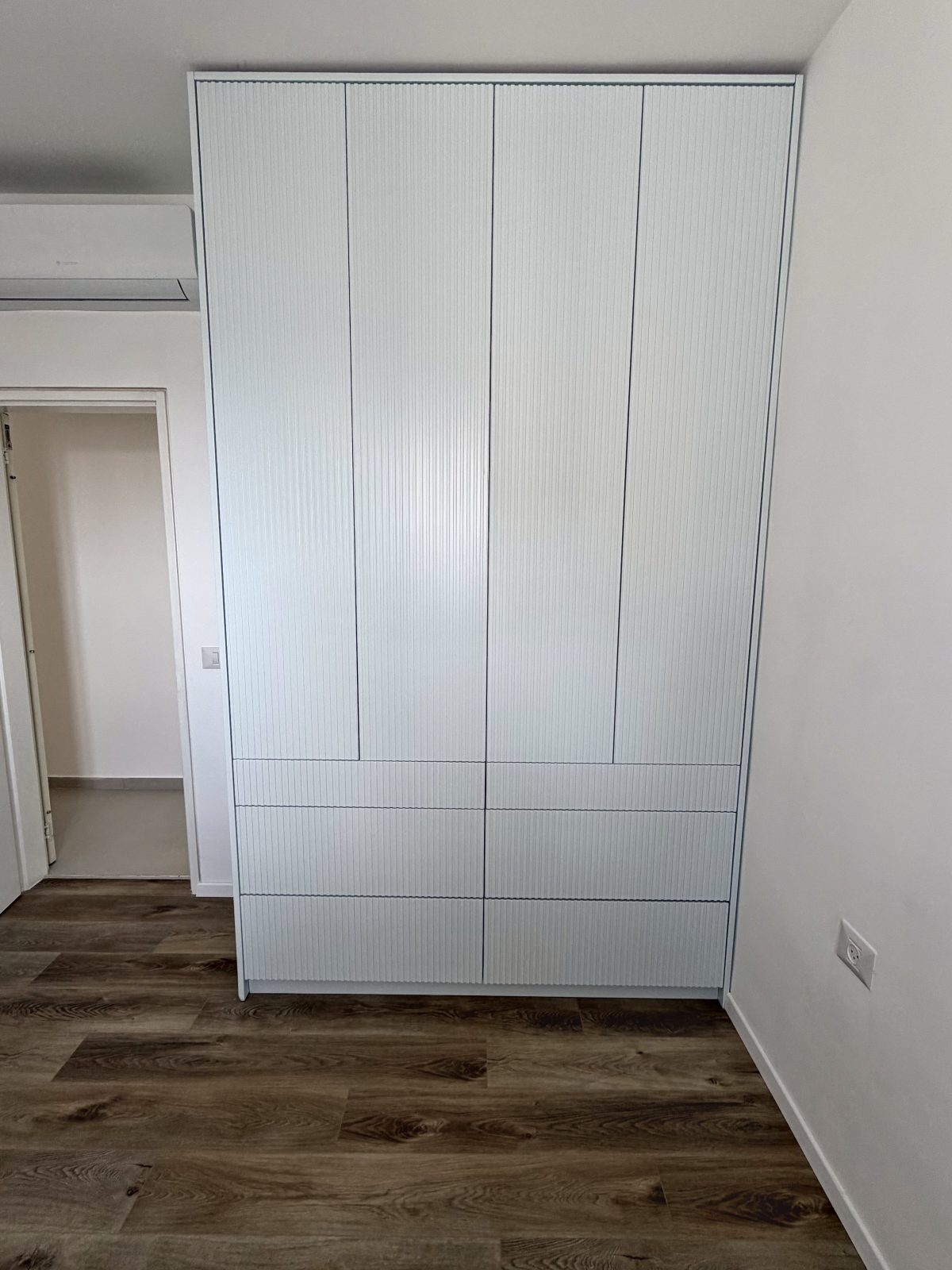 ארון קיר לבן בחזית פסים עם מגירות